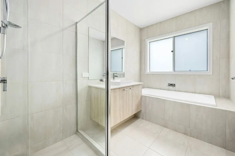 Marble walk-in shower with glass enclosure