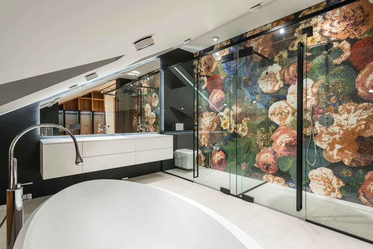 Elegant bathroom featuring a freestanding bathtub and floral mosaic wall in a modern interior