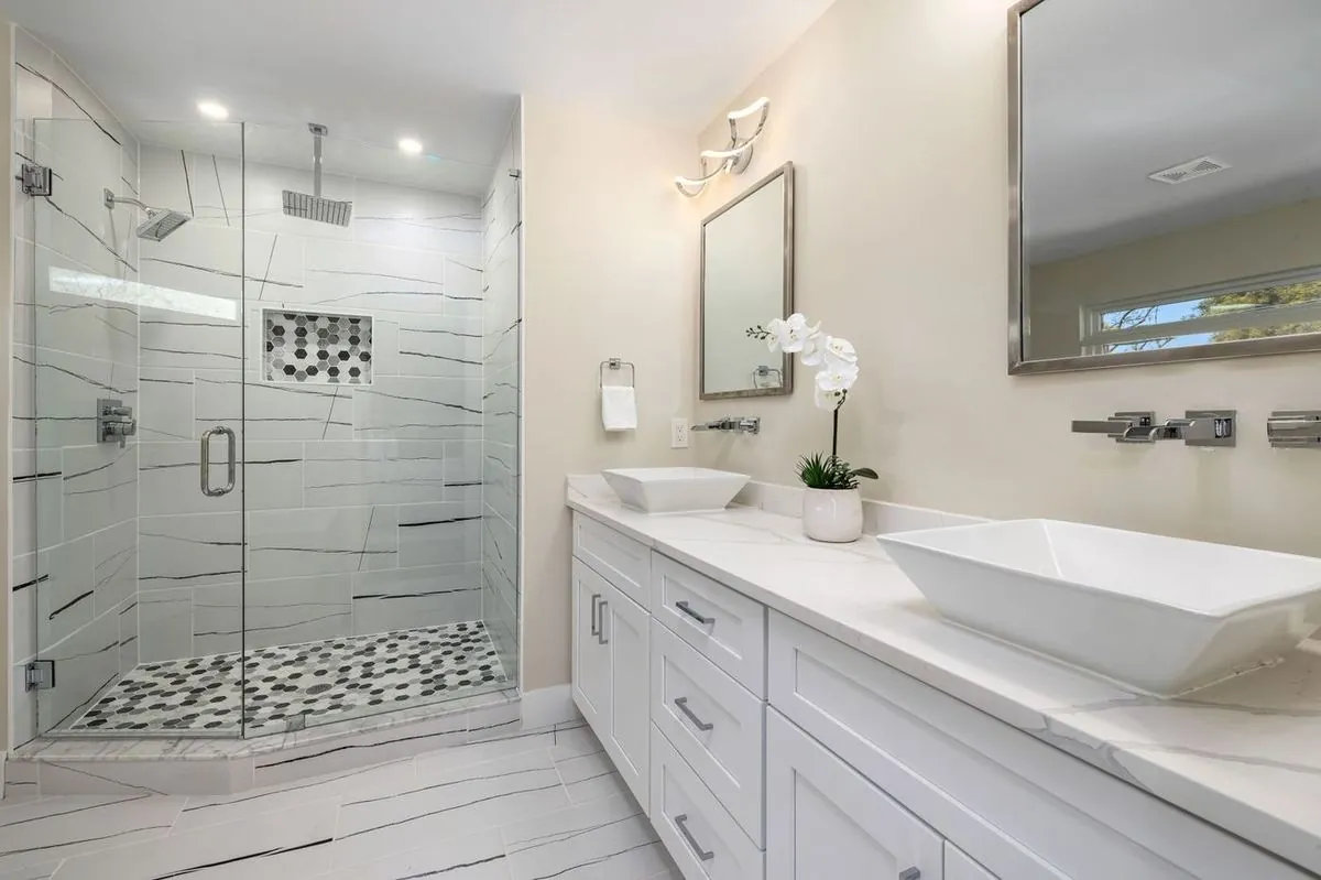 Luxurious contemporary bathroom featuring a spacious glass shower and dual sinks
