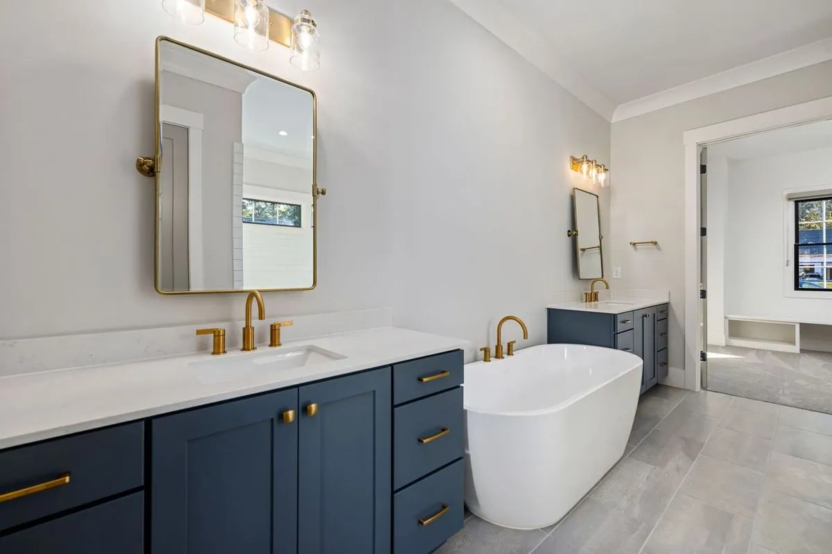 Luxurious bathroom with freestanding bathtub between dual-sink counters and modern fixtures