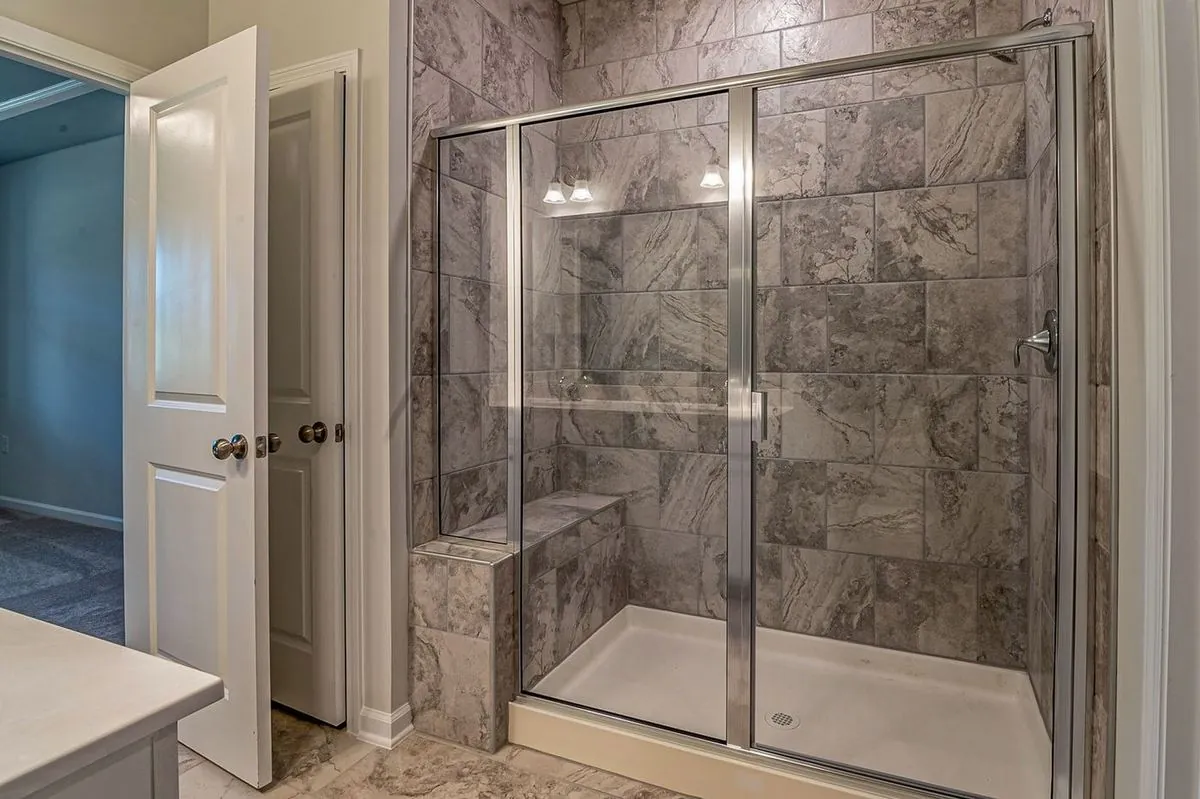 Luxurious modern bathroom with marble tiled shower and sleek glass doors