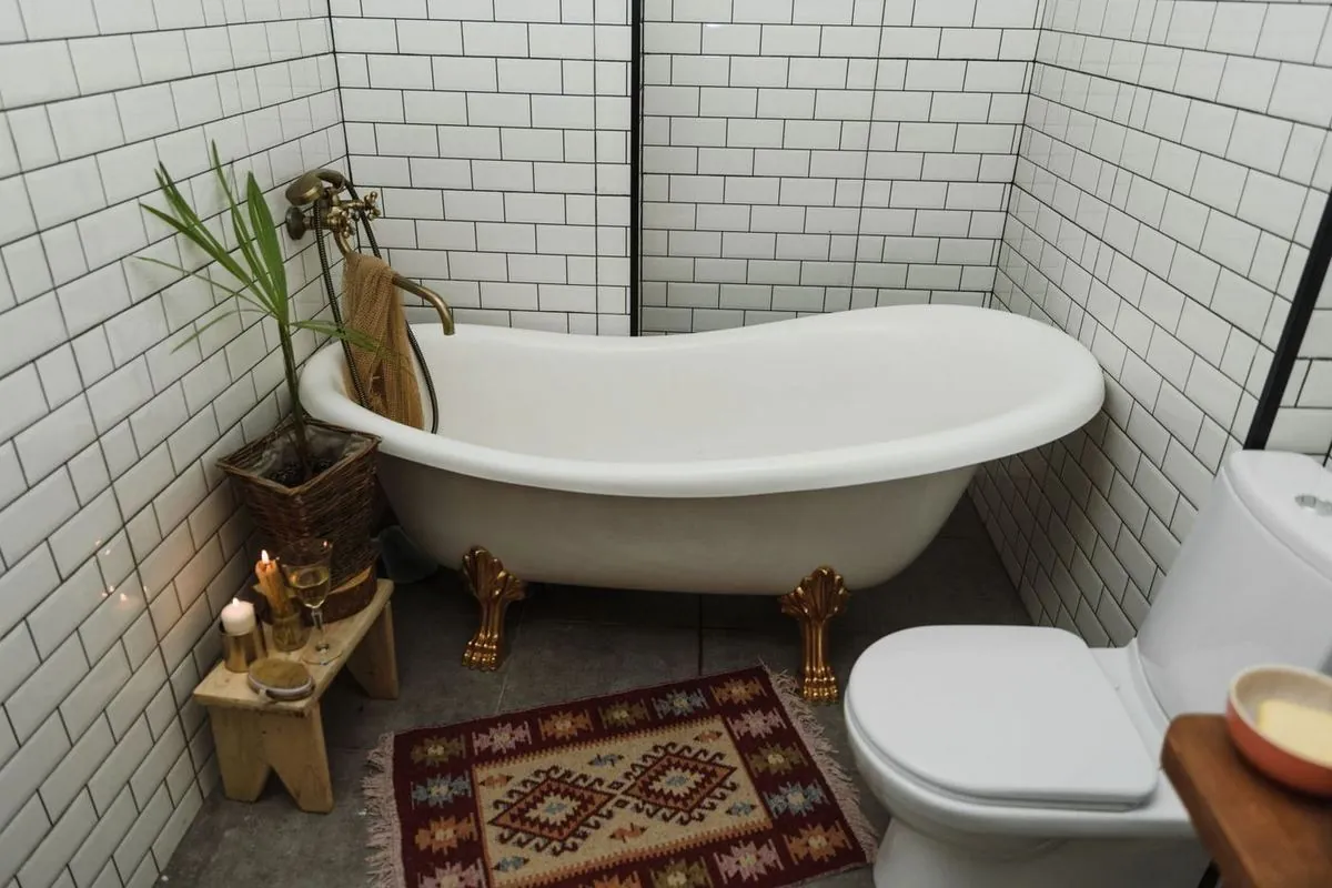 Cozy bathroom with a vintage-style clawfoot bathtub, white tiles, and patterned rug