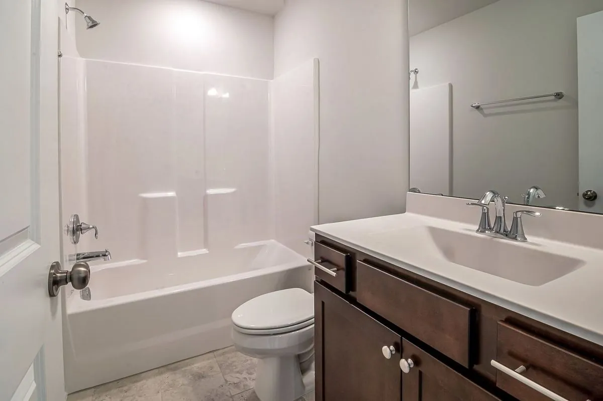 Simple bathroom layout with a bathtub, sink, and toilet.