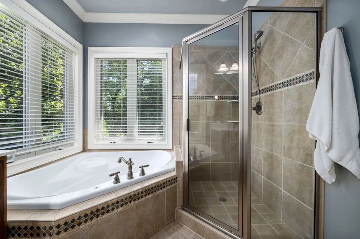 Bathroom with a glass shower, soaking tub, and large windows.