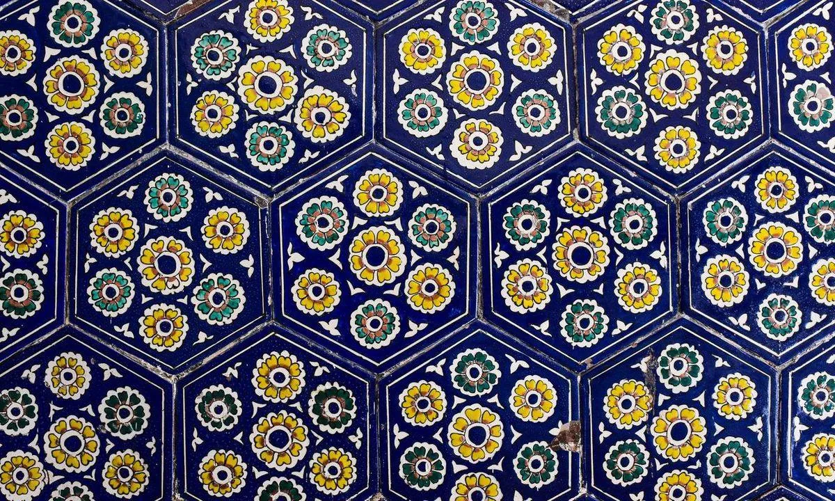 Close-up of colorful floral mosaic tiles in a hexagonal pattern.