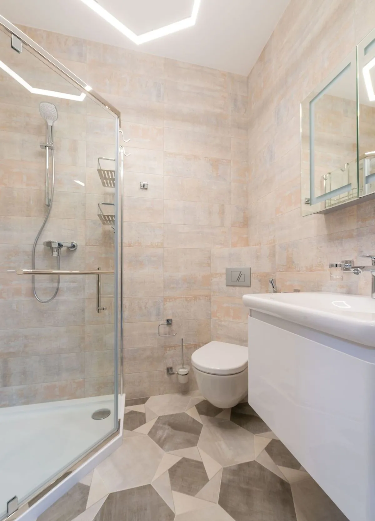 Ceramic sink beside a glass-door shower in a bright modern bathroom.