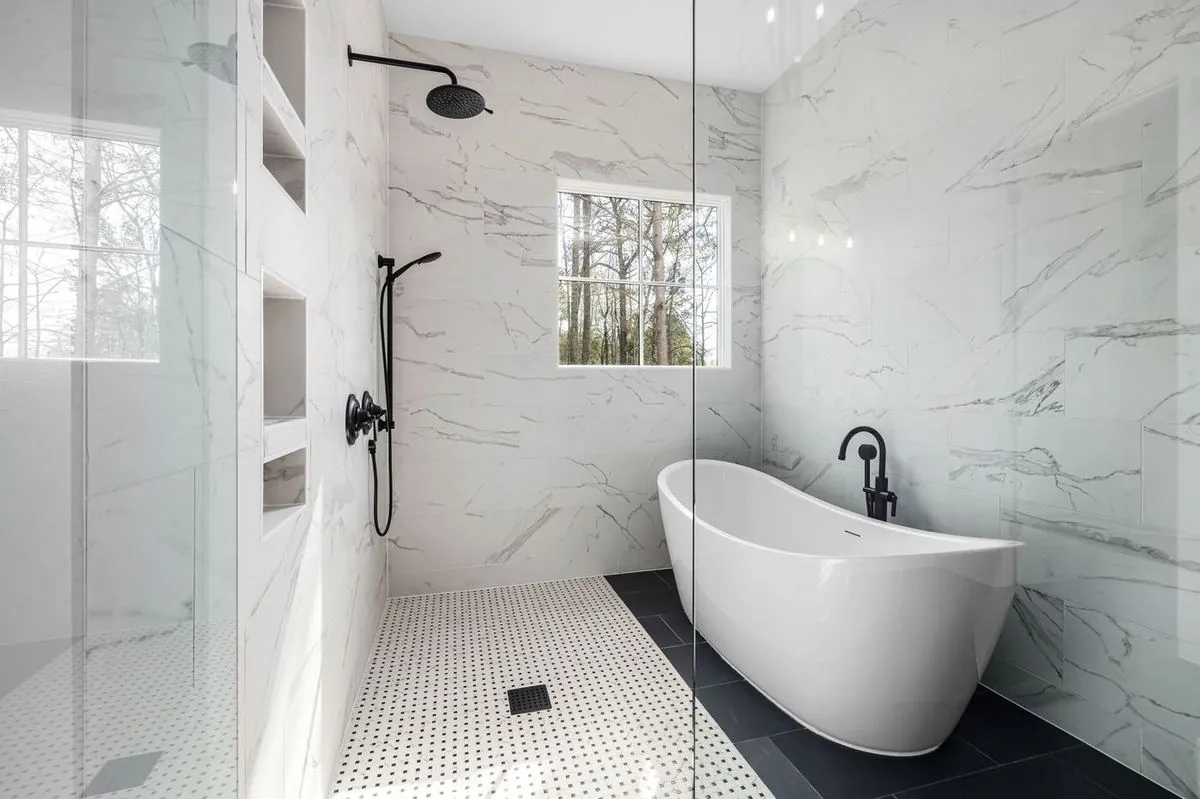 Sleek modern bathroom with a freestanding bathtub and marble walls.