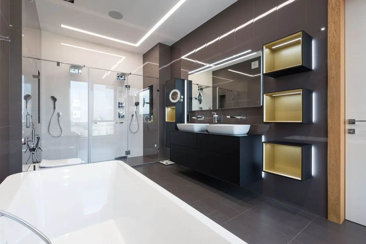 Spacious modern bathroom with a bathtub and glass shower cabin.