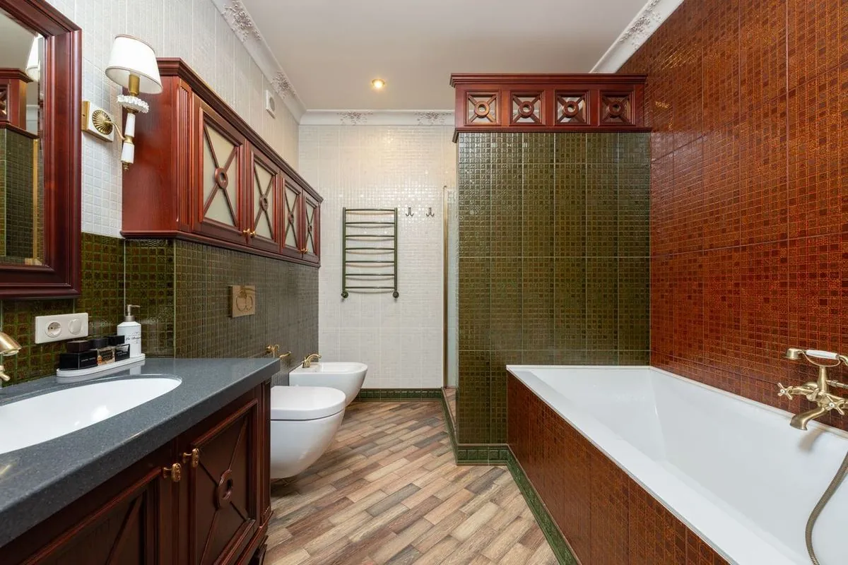 Traditional bathroom with white vanity and bathtub, green and brown tones, classic tiles