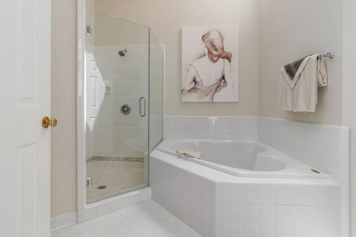 Modern minimalist bathroom with a glass shower and bathtub, simple and clean.