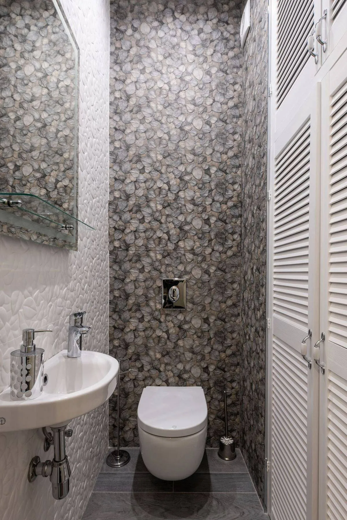Stylish and compact bathroom featuring modern fixtures, elegant tiles, and a minimalist sink and toilet setup.