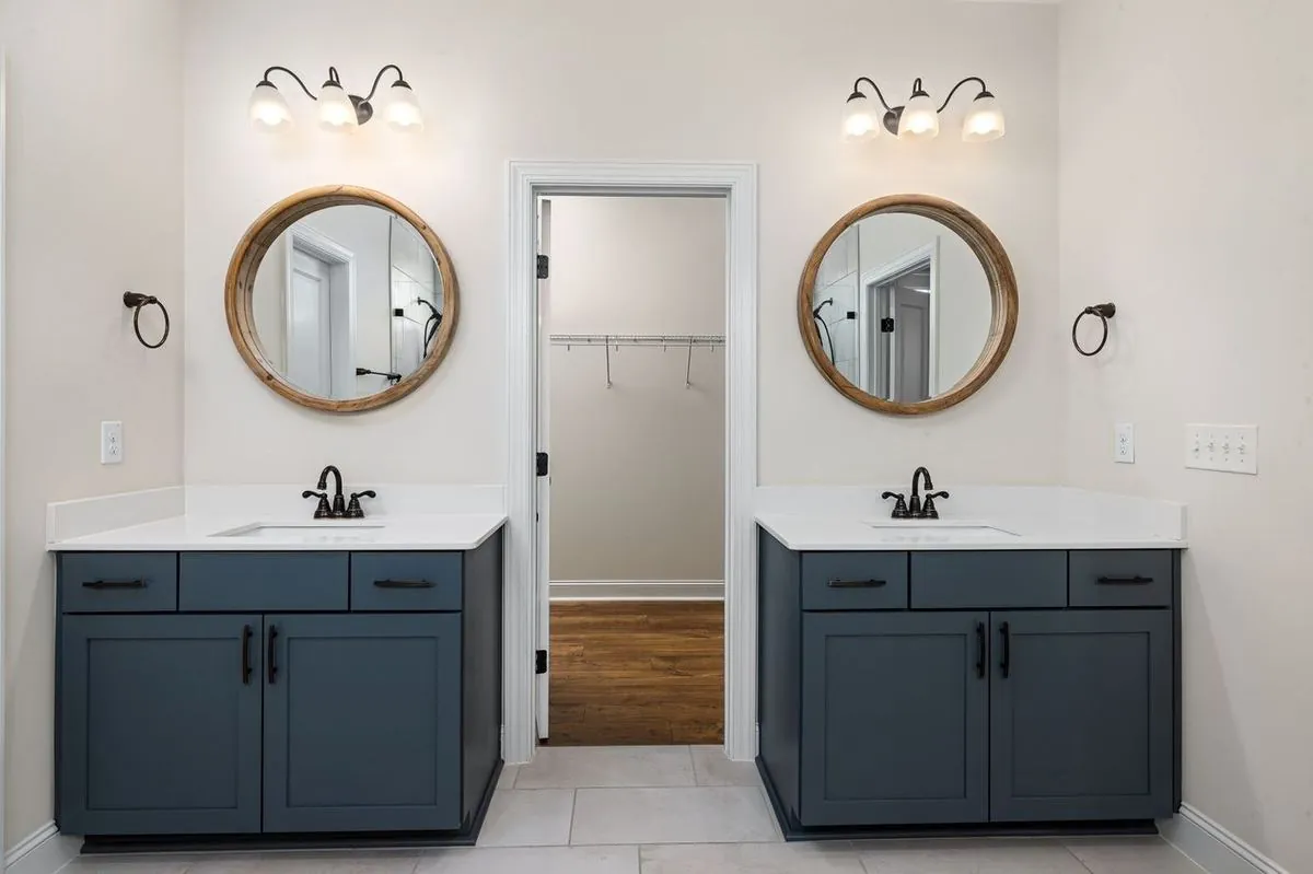 Modern bathroom with dual sinks, round mirrors, and stylish lighting