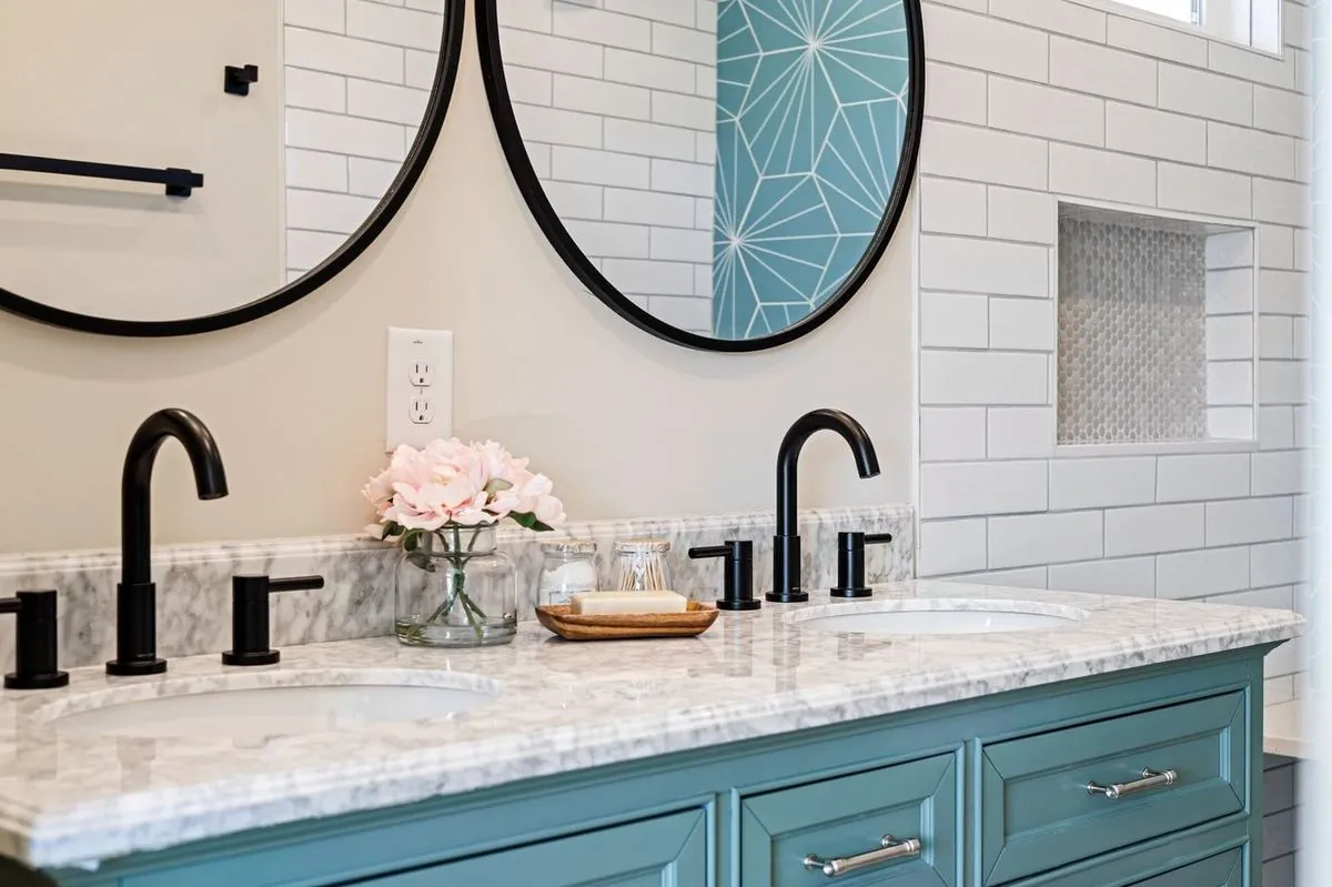 Modern bathroom with double sinks, round mirrors, black fixtures, and ceramic tile walls