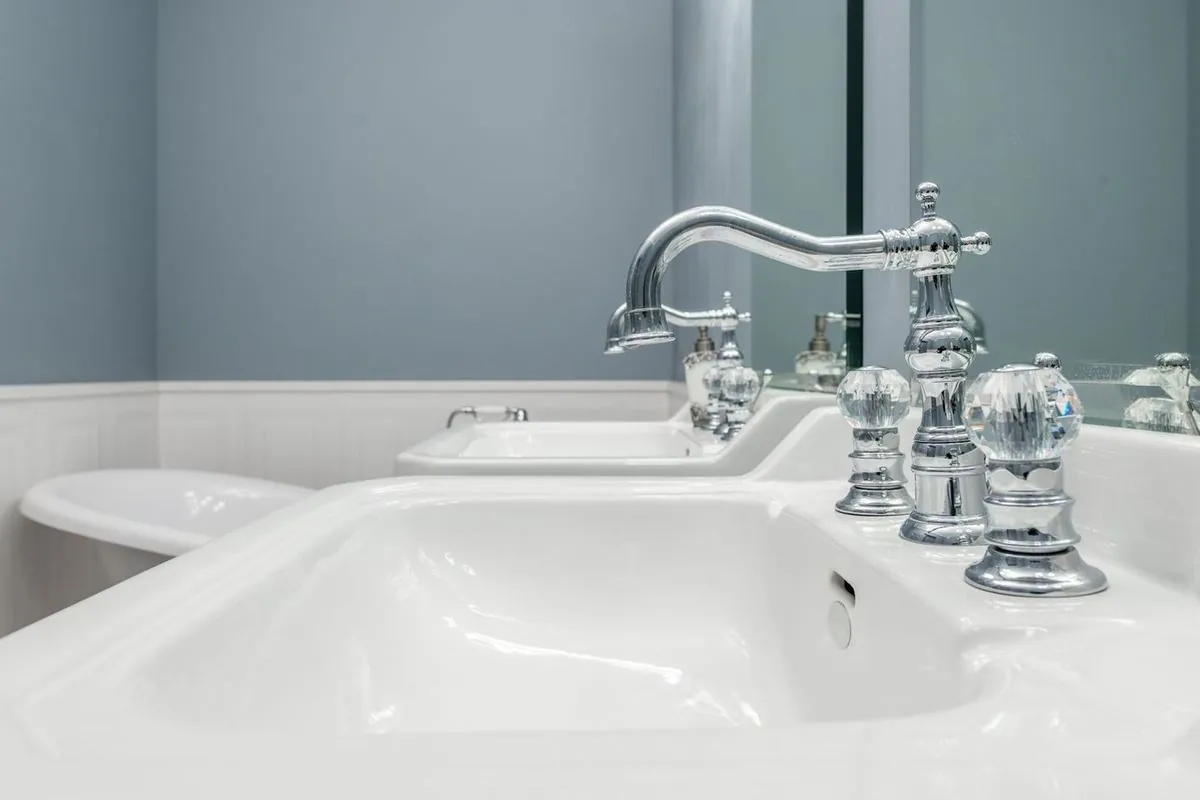 Bright bathroom with white sinks and stylish faucets.