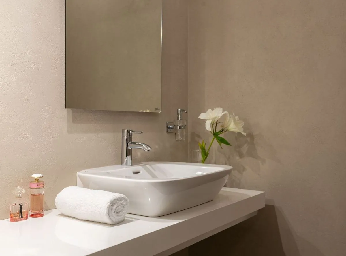 White sink and mirror with towel in bathroom.