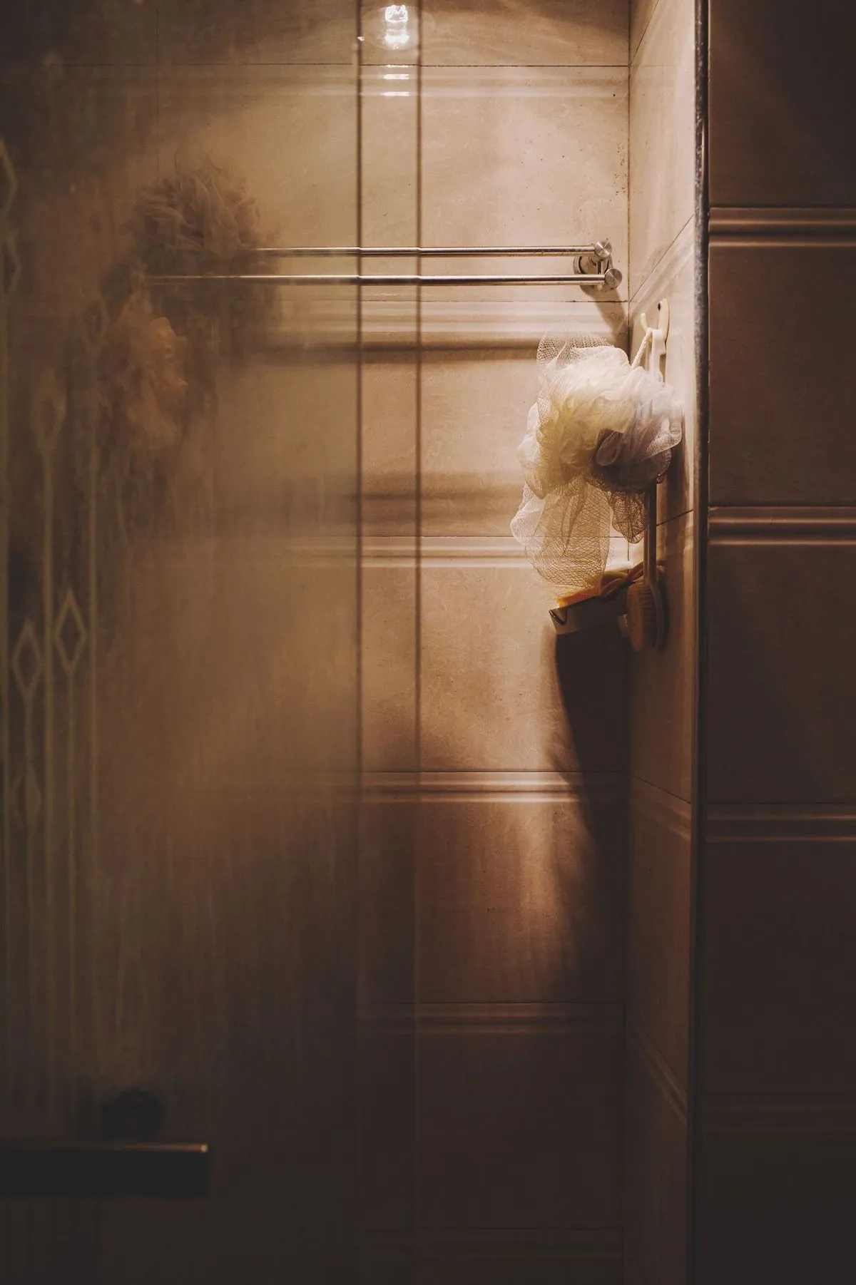 Cozy bathroom setting with soft shadows and ambient lighting, featuring a shower and wooden wall elements.