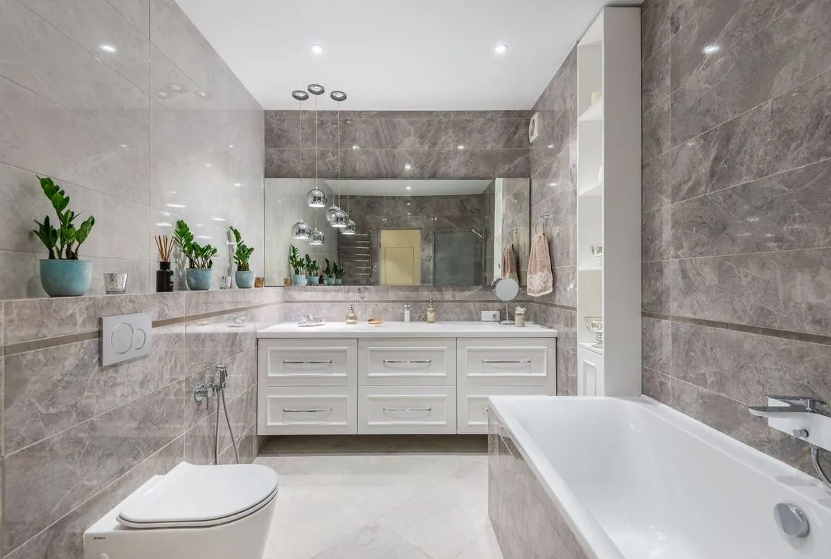 Spacious bathroom with bathtub and mirror hanging over a white cupboard