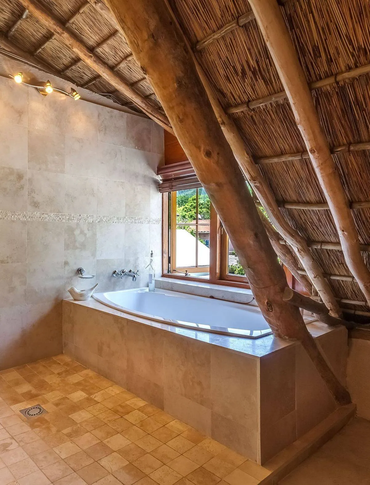 Rustic elegant bathroom with a bathtub beside an open window