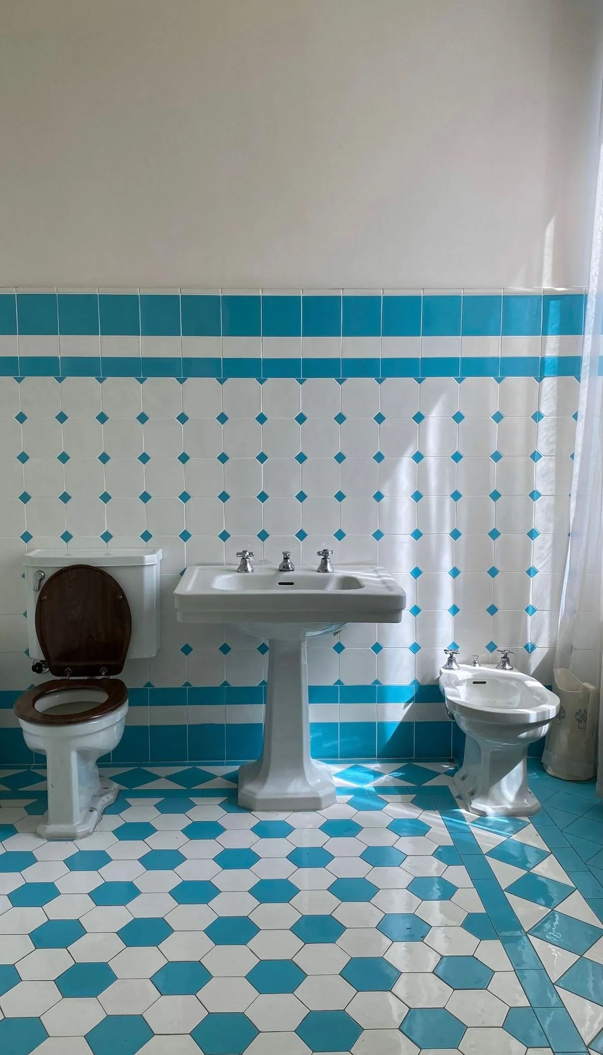 Elegant blue and white tiled bathroom with sink, toilet, and bidet