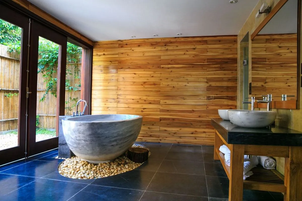 Modern marble tub in a warm wood-paneled bathroom for a serene escape