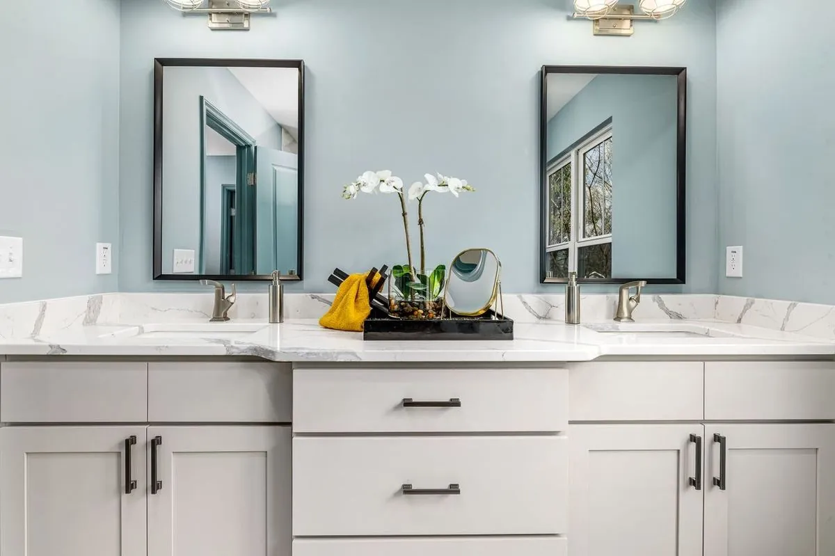 Double vanity with twin vessel sinks, marble countertop and framed mirrors.