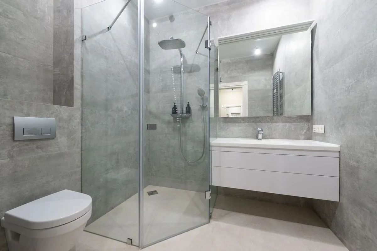 Elegant modern bathroom with glass shower cabin, washbasin, and sleek chrome fixtures
