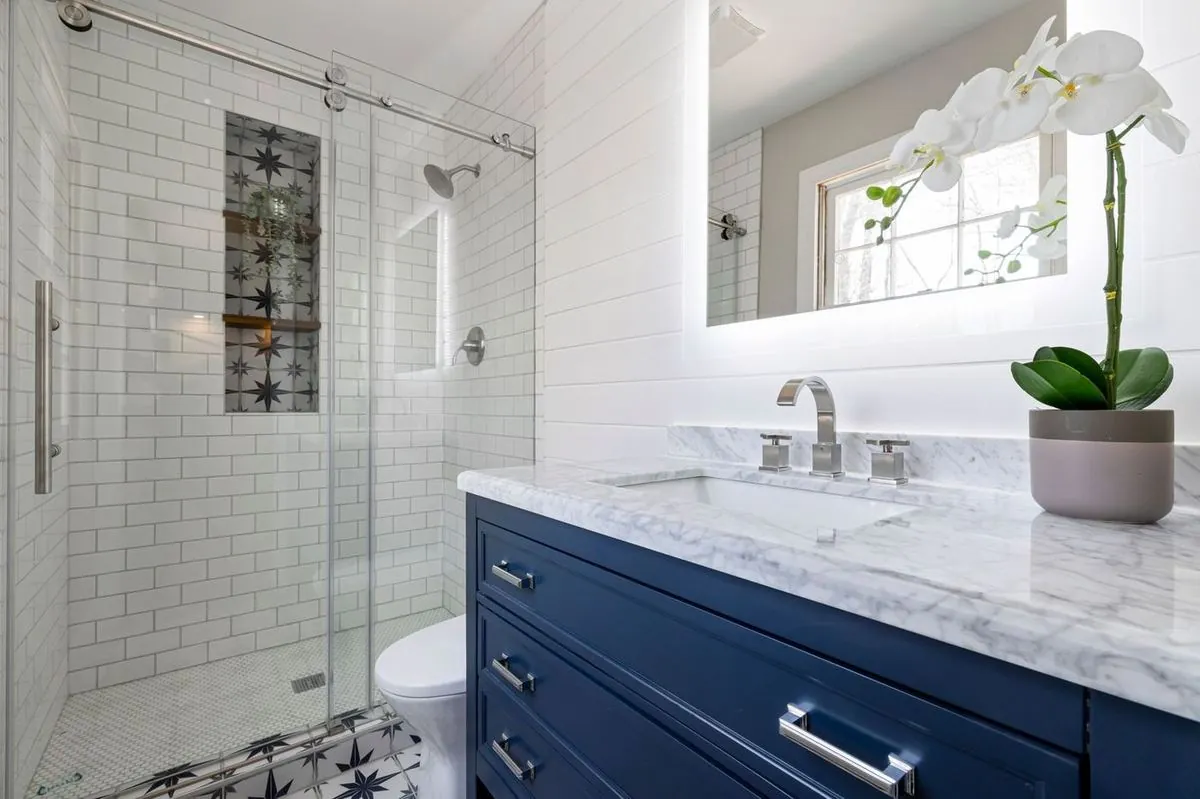 Stylish bathroom interior with marble countertop and glass shower